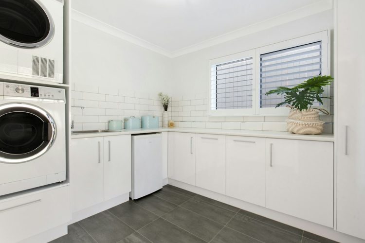Washer and dryer in a white kitchen nook, one of the small laundry room ideas